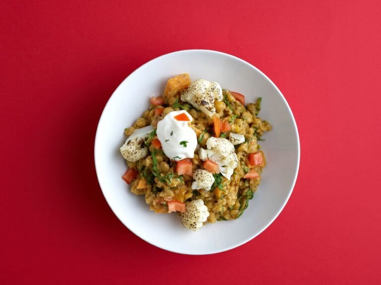 Cauliflower curry with spices in a white bowl