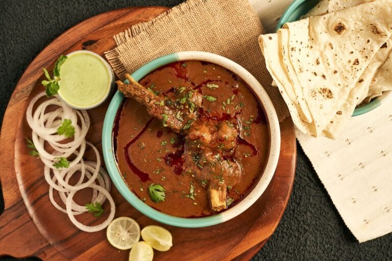 Slow-cooked beef curry served with flatbread, onions and herbs