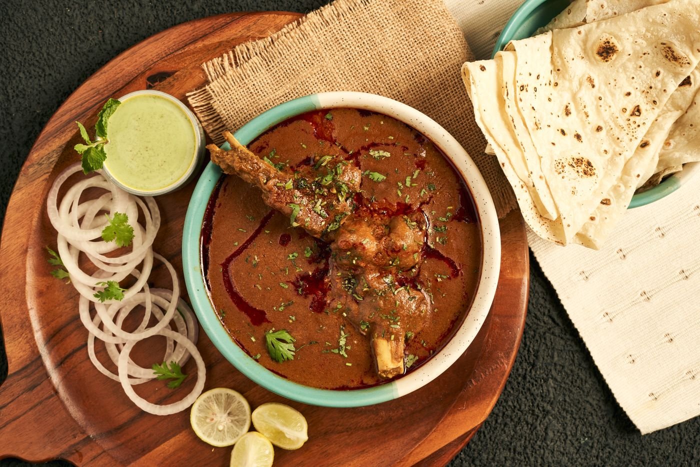 Slow-cooked beef curry served with flatbread, onions and herbs