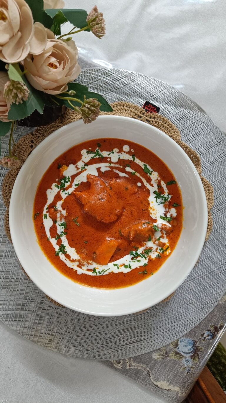 Butter chicken in a creamy tomato sauce garnished with cream