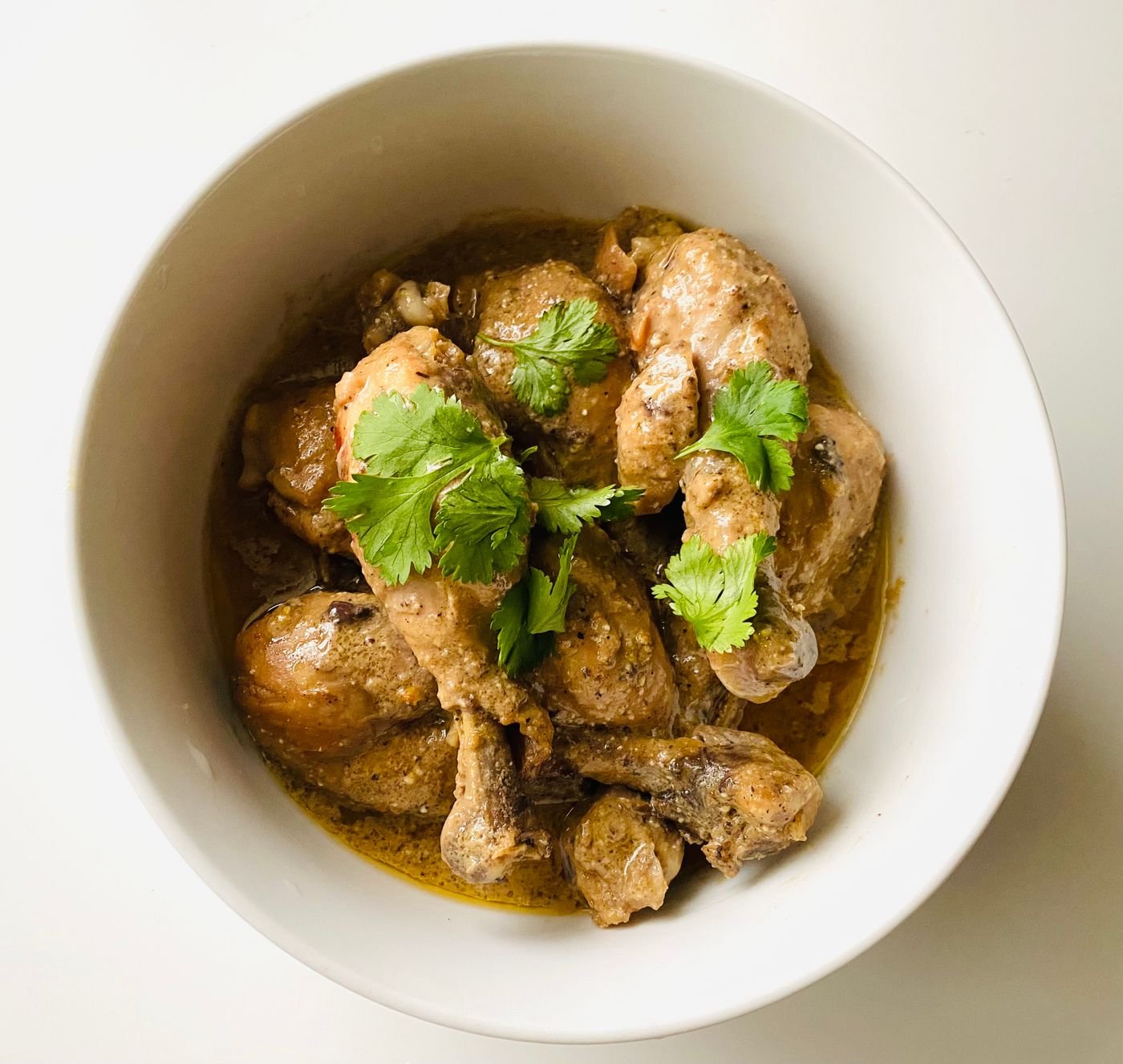 A bowl of chicken curry garnished with fresh cilantro