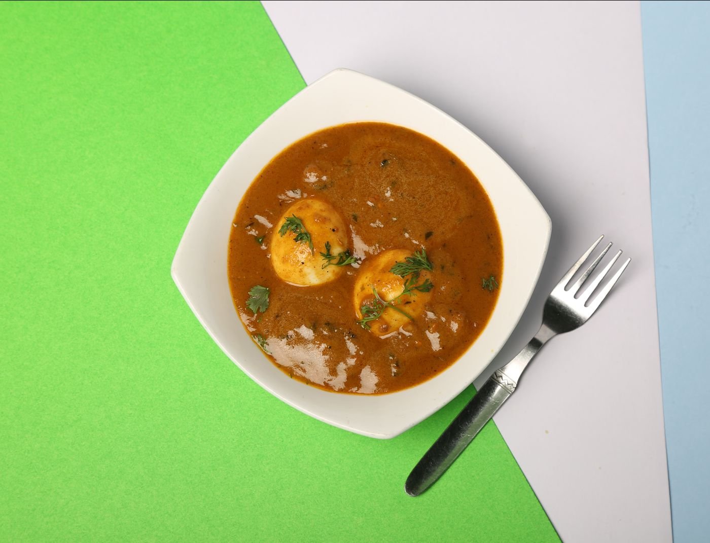 Egg curry in a white bowl, top view
