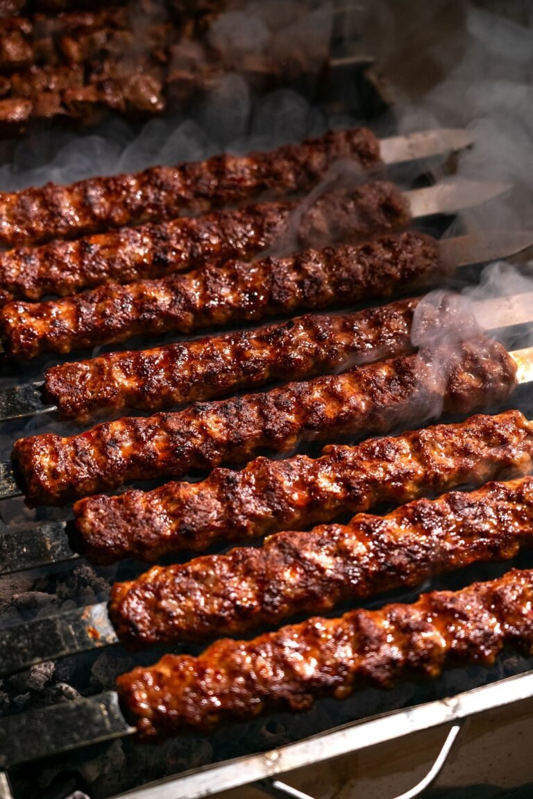 Grilled kebabs sizzling on a barbecue, close-up