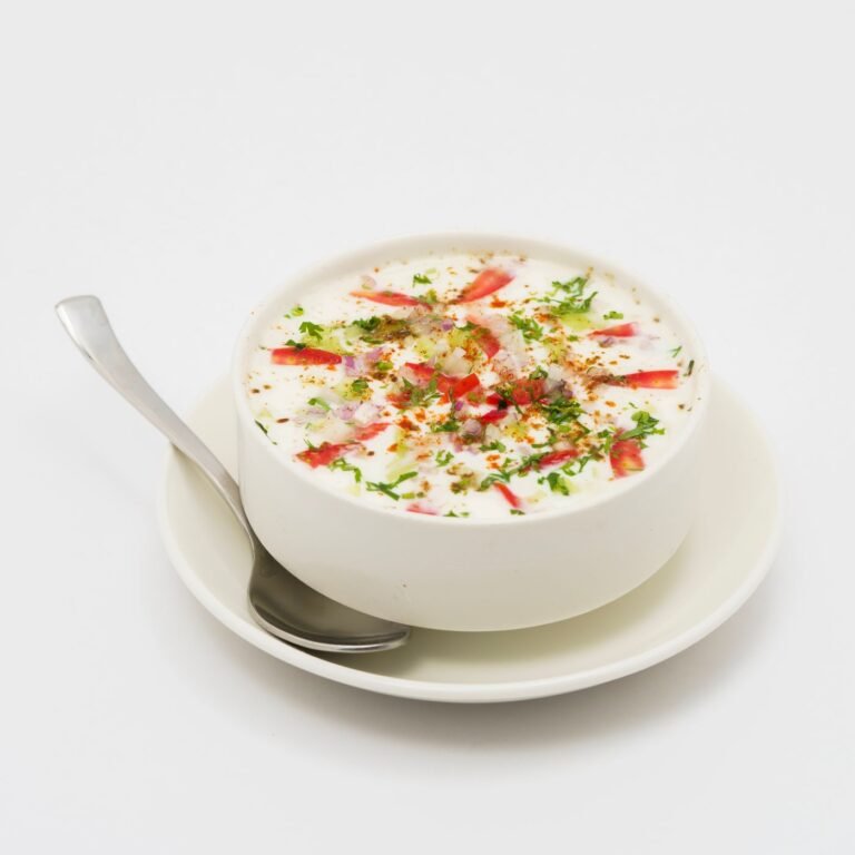 A bowl of creamy raita with fresh vegetables