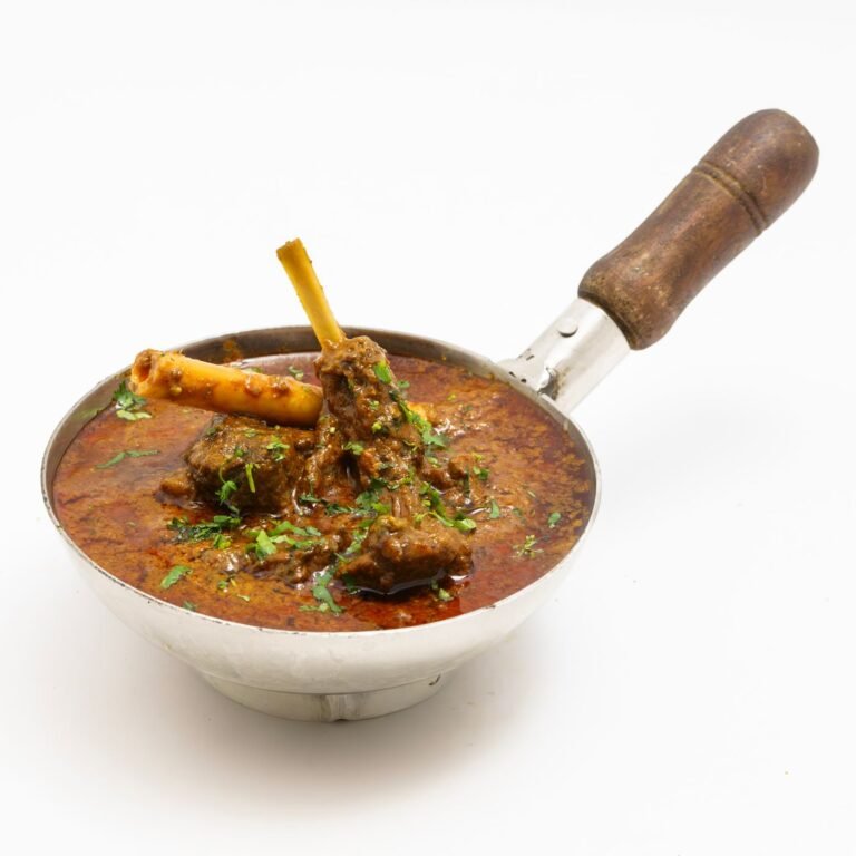Mutton curry served in a traditional steel pan
