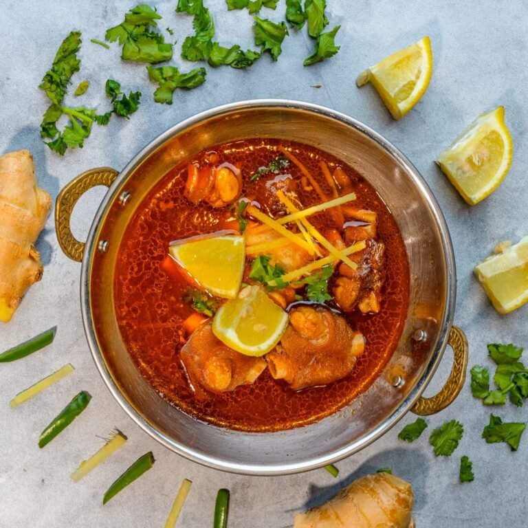 Spicy lamb karahi garnished with coriander and lemon