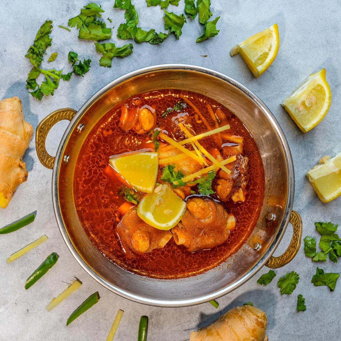 Spicy lamb karahi garnished with coriander and lemon